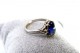 Anel em ouro branco com diamantes (4) em talhe brilhante e safira azul no centro