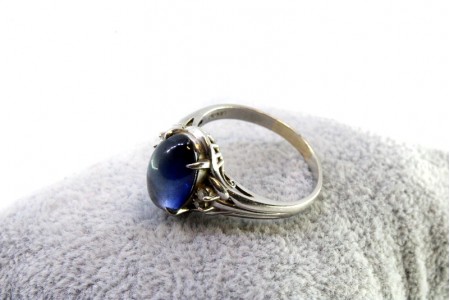 Anel em ouro branco com diamantes (4) em talhe brilhante e safira azul no centro