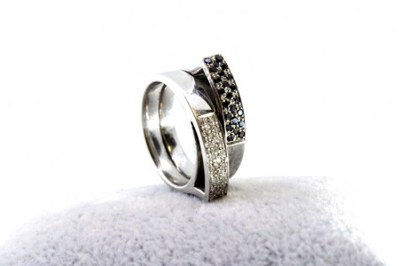  Anel em ouro branco com duas bandas de diamantes (40) brancos e negros, alternados em talhe brilhante.