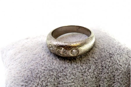 Anel em ouro branco com três diamantes em talhe brilhante com cravação inglesa.