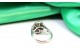 Anel em ouro branco com (4) diamantes e esmeralda ovalizada ao centro