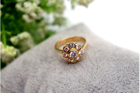 Anel em ouro com nove (9) diamantes em talhe brilhante e em forma de flor.