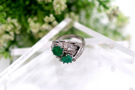 Anel em ouro branco com diamantes (19) em talhe brilhante e duas esmeraldas incr