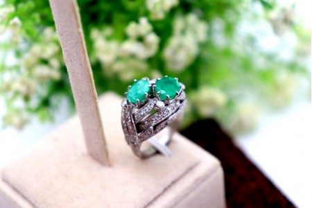 Anel em ouro branco com diamantes (19) em talhe brilhante e duas esmeraldas incr