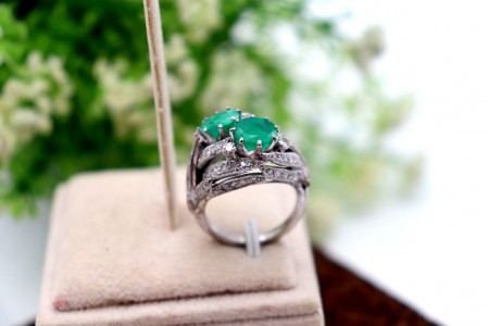 Anel em ouro branco com diamantes (19) em talhe brilhante e duas esmeraldas