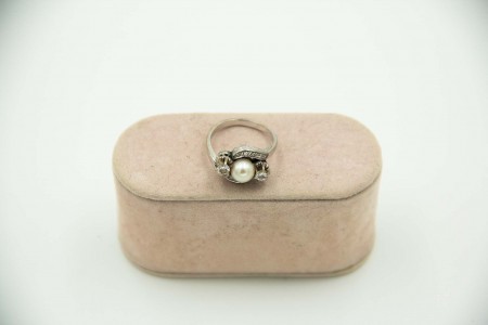 Anel em ouro branco com pérola de cultura e diamantes (2) em talhe brilhante  e 