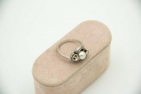 Anel em ouro branco com pérola de cultura e diamantes (2) em talhe brilhante  e 