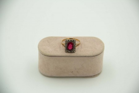 Anel em ouro e prata com lascas de diamantes envolvendo mesa com rubi lapidado