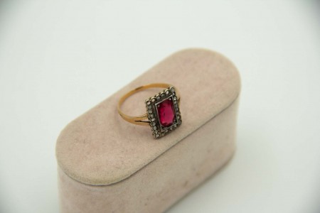 Anel em ouro e prata com lascas de diamantes envolvendo mesa com rubi lapidado