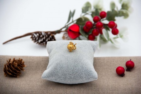 Berloque em ouro em formato de bule.