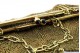 Bolsa em malha de ouro de dois tons, com arco liso, cabochões negros no fecho 