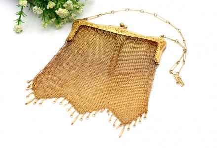 Bolsa em malha de prata dourada com arco relevado e pingentes articulados