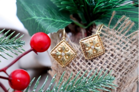 Brincos em ouro com relevos e pérolas no centro.