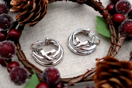 Brincos em ouro com (20) diamantes em talhe brilhante, entrelaçados lisos e fecho omega.