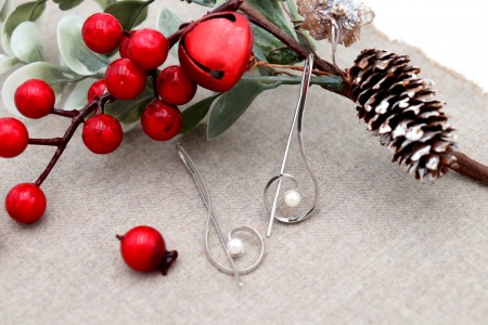 Brincos em ouro branco em forma de clave de sol com pérolas de cultura.