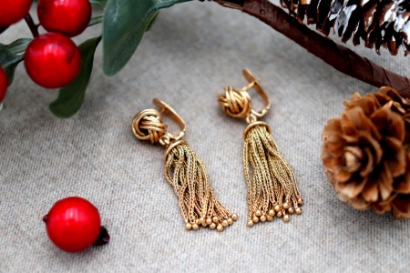 Brincos em ouro em forma de nós com pingentes articulados.