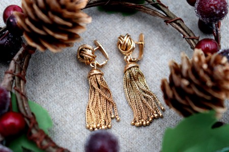 Brincos em ouro em forma de nós com pingentes articulados.