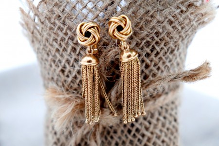 Brincos em ouro em forma de nós com pingentes articulados.