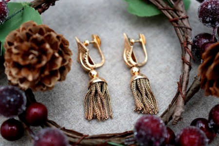 Brincos em ouro em forma de nós com pingentes articulados.