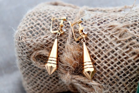 Brincos em ouro em formato pião com relevos