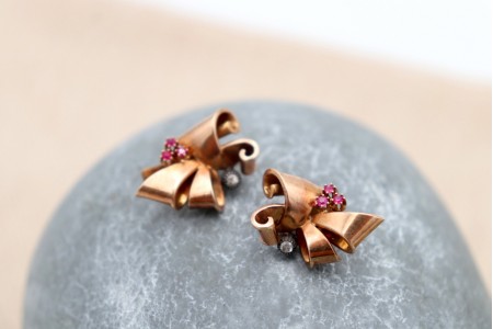 Brincos em ouro em forma de laços com pedras brancas e (6) rubis sintéticos calibrados.