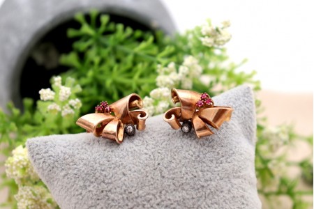 Brincos em ouro em forma de laços com pedras brancas e (6) rubis sintéticos calibrados.