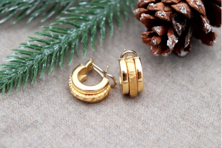 Brincos em ouro lisos com aro martelo no centro com fecho omega.