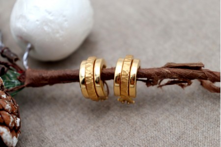 Brincos em ouro lisos com aro martelo no centro com fecho omega.