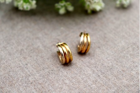 Brincos -  argolas de ouro bicolores com três bandas lisas.