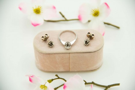 Conjunto de brincos e anel solitárioa em ouro branco com diamantes em talhe brilhante.