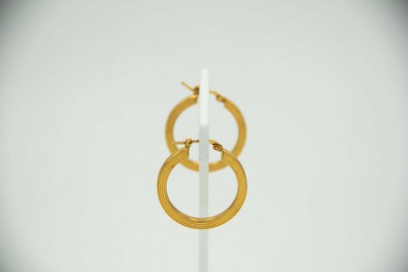 Brincos em forma de argolas de ouro amarelo com faixas relevadas.