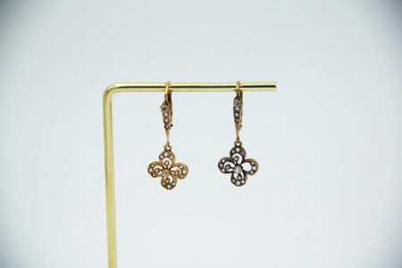 Brincos em ouro amarelo em forma de trevos basculantes com pedras incolores.