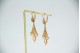 Brincos em ouro amarelo em formato de flor de liz articulados com pérolas aplica