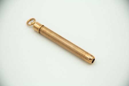 Lapiseira em ouro amarelo com gravados guilhochados e argola de suspensão.