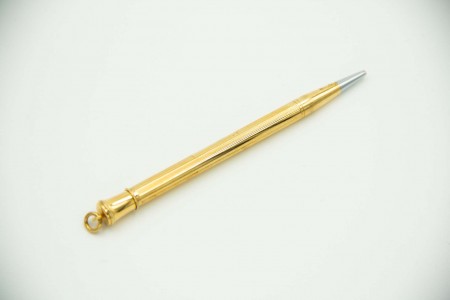 Lapiseira em ouro amarelo guilhochado com cartela para monograma.