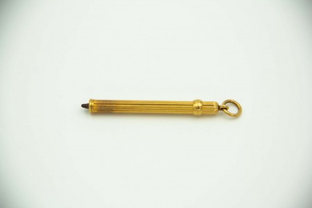 Porta-Lápis de ouro com relevos canelados e argola de suspensão.