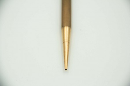 Lapiseira em ouro guilhochada, argola de suspensão e cabeça sextavada.