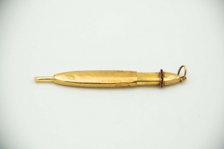 Lapiseira em ouro amarelo em formato elíptico, frido com rubis calibrados