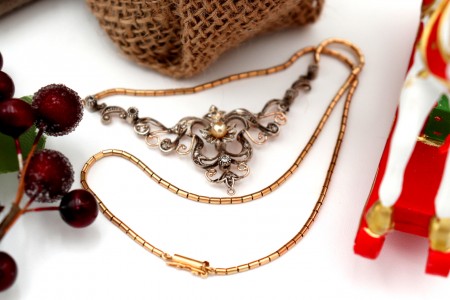 Colar em ouro e prata com lascas de diamante e pérola de cultura no centro.