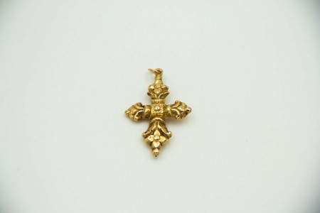 Cruz barroca em ouro amarelo com relevos.