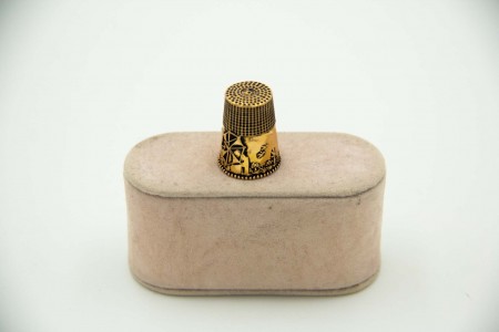 Dedal em ouro amarelo com relevos e friso envolvente