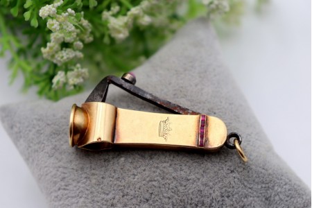 Corta cigarrilhas vintage em ouro com aplicações de rubis e argola de suspensão
