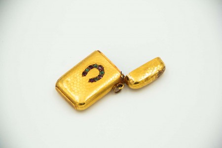 Fosforeira em ouro amarelo com relevos simétricos e aplicação de esmeraldas