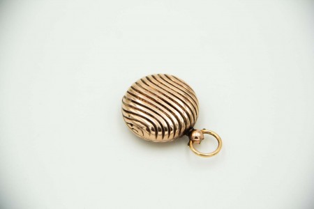 Porta libras em formato circular em ouro amarelo com relevos simétricos