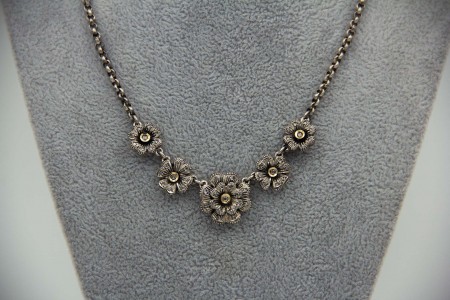 Gargantilha em ouro bicolor com flores articuladas e diamantes (53) coroados.