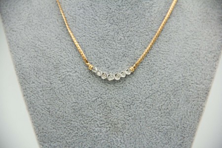 Gargantilha em ouro bicolor com diamantes (7) em talhe brilhante aplicados no ce