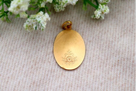 Medalha em ouro com Nossa Senhora orando em vulto perfeito relevado e argola de suspensão.