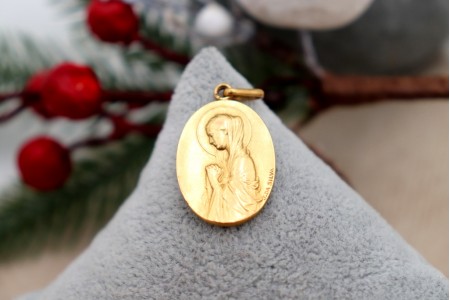 Medalha em ouro com Nossa Senhora orando em relevo e argola de suspensão.