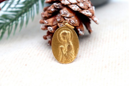 Medalha em ouro com Nossa Senhora orando em vulto perfeito relevado e argola de suspensão.