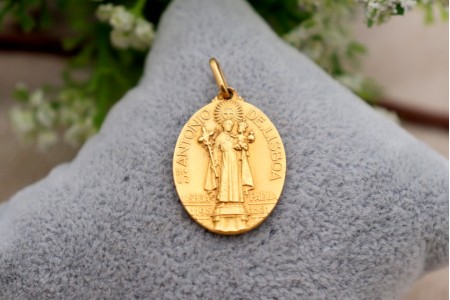 Medalha em ouro com imagem de Santo António de Lisboa em vulto perfeito relevado e argola de suspensão.